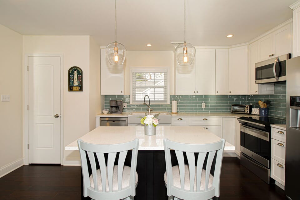 Island seating lets you chat with anyone working in the kitchen. Cleaning supplies in the closet.