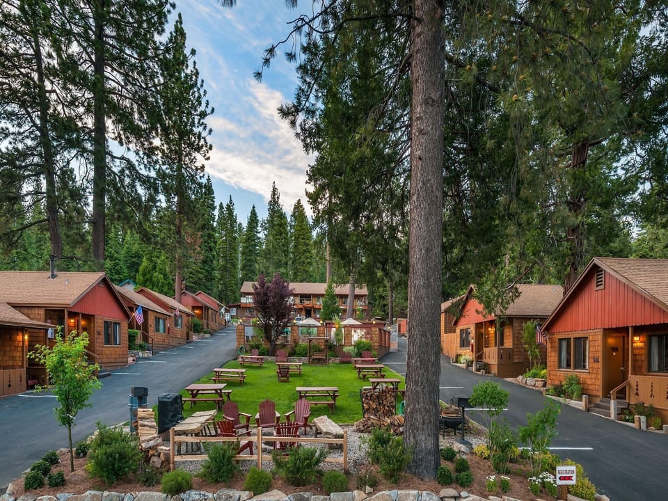 Cedar Glen Lodge Property Layout. Cabins on both sides facing the central area. Fire pit, picnic tables, bbqs, hot tub, large heated swimming pool, mini putting green, and ping pong on property.