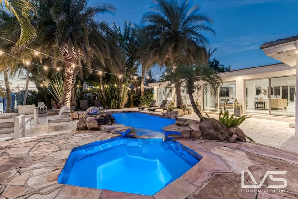 Waterfront Resort Style Oasis with Salt Water Heated Pool, Spa, Tiki Hut & Bar, Outdoor Kitchen, Outdoor Dining Area, 80' Deep Water Dock / Floating Dock with no fixed bridges to Intercoastal.  Plenty of Seating Areas, a Hammock & much more!!