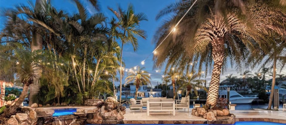 Waterfront Resort Style Oasis with Salt Water Heated Pool, Spa, Tiki Hut & Bar, Outdoor Kitchen, Outdoor Dining Area, 80' Deep Water Dock / Floating Dock with no fixed bridges to Intercoastal.  Plenty of Seating Areas, a Hammock & much mor
