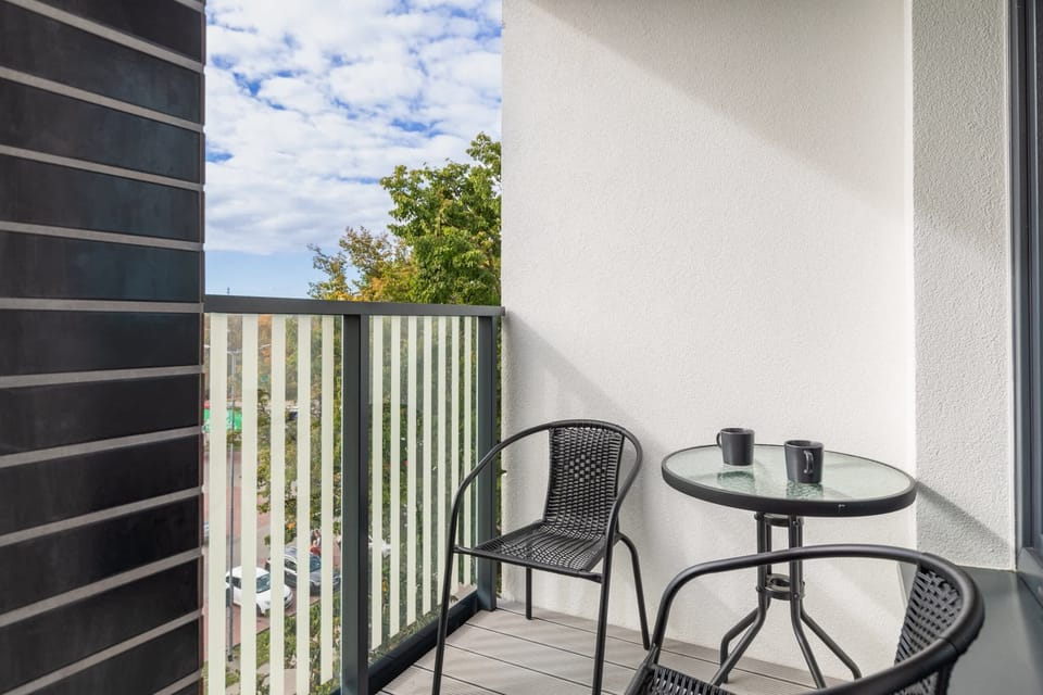 Balcony with a small table and chairs, ideal for enjoying the fresh air and surrounding views.
