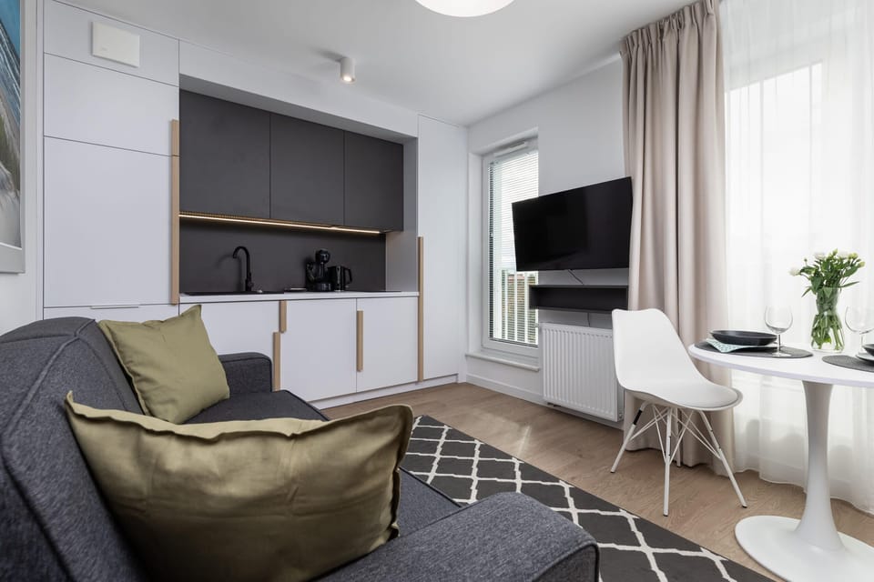 Spacious living area with a modern sofa and large windows letting in ample natural light.

