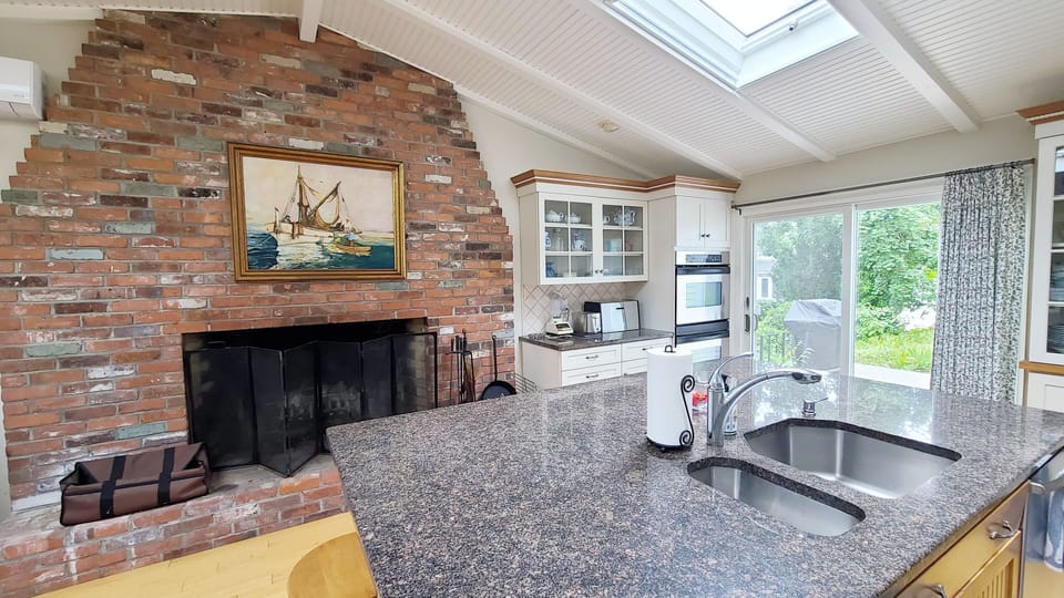 Kitchen has a large island and a decorative fireplace