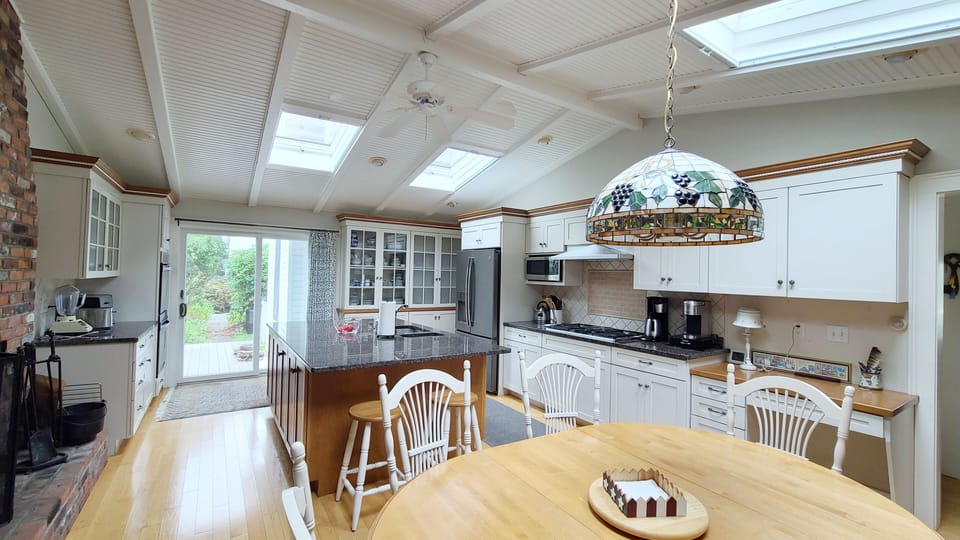 Open and bright kitchen has vaulted ceiling and skylights