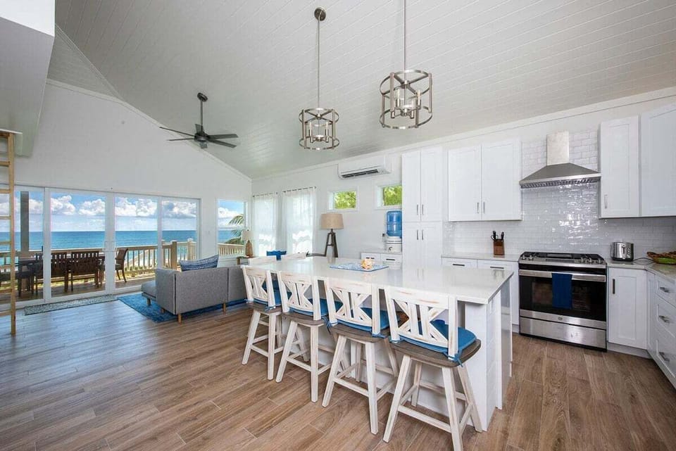 The luxurious modern kitchen is fully equipped and finished in white quartz and stainless steel.