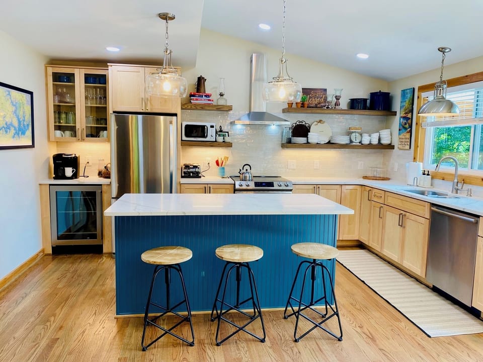 Fully stocked kitchen including a beverage fridge and island seating.