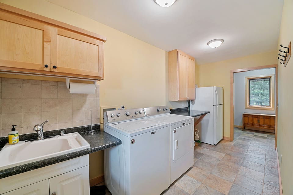 Conveniently located laundry room with deck access and additional refrigerator