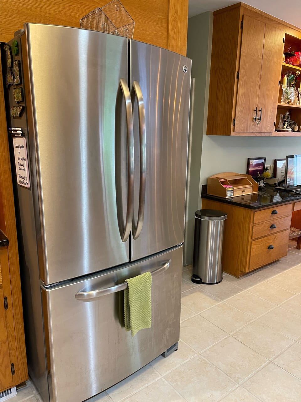 GE Stainless Refrigerator, ice maker in freezer drawer, water bottles in fridge.