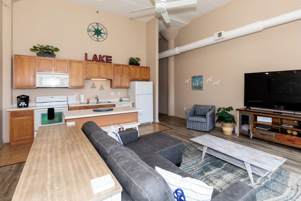 Relax in your spacious open-concept living area with modern kitchen, comfy seating, and thoughtful lake-themed touches.