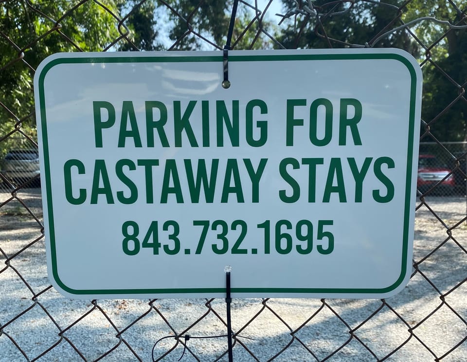 FOUR designated spaces are marked along the fence to the right of the driveway as you enter from the street.