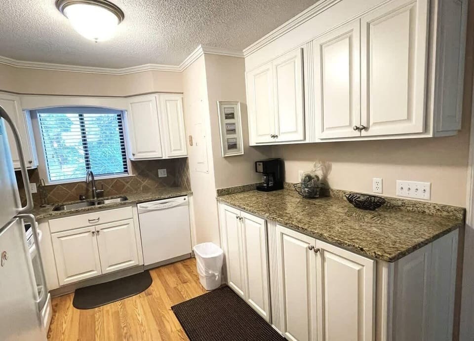 Kitchen with Washer & Dryer
Prepare meals in a clean, modern kitchen with white cabinetry and granite countertops.
