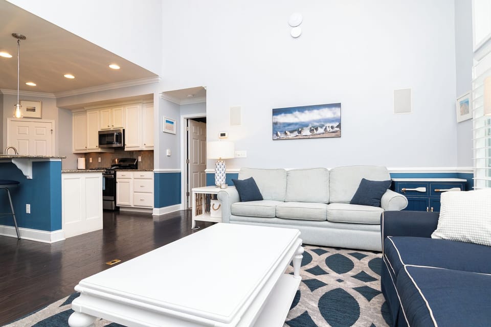 Open-concept first-floor living room with kitchen and dining area nearby.