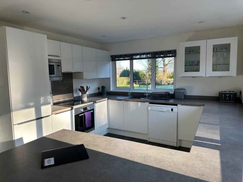 Kitchen with full crockery, cutlery, cooking equipment & significant storage