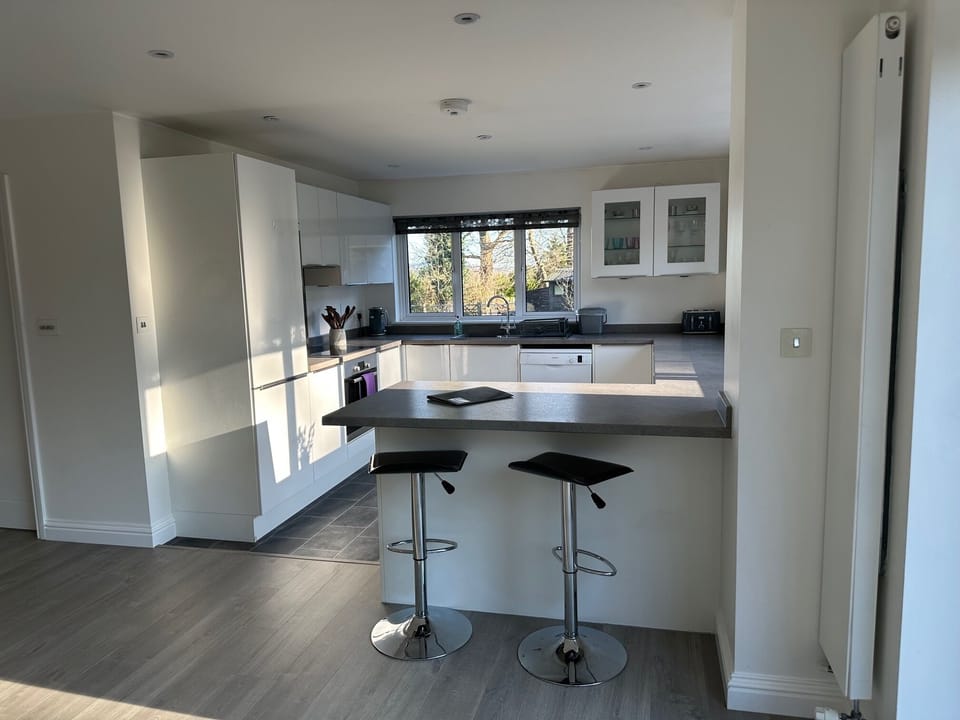 Kitchen with oven, hob, microwave, tall fridge, dishwasher, toaster & kettle