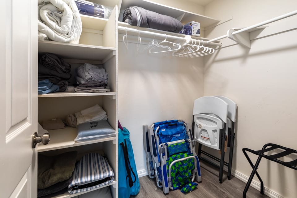 Walk in closet with lots of extra bedding, towels + Supplies and beach chairs