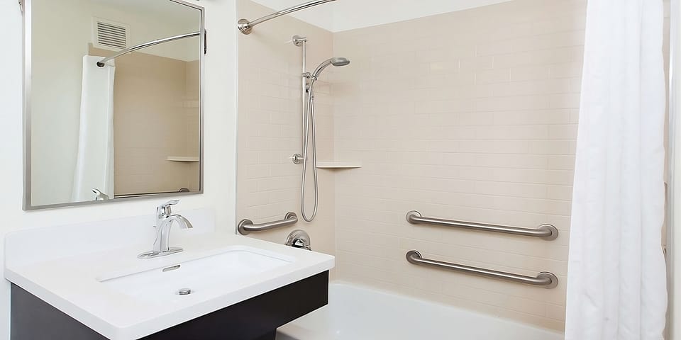 Enjoy an easy, comfortable soak in the clean bathtub.