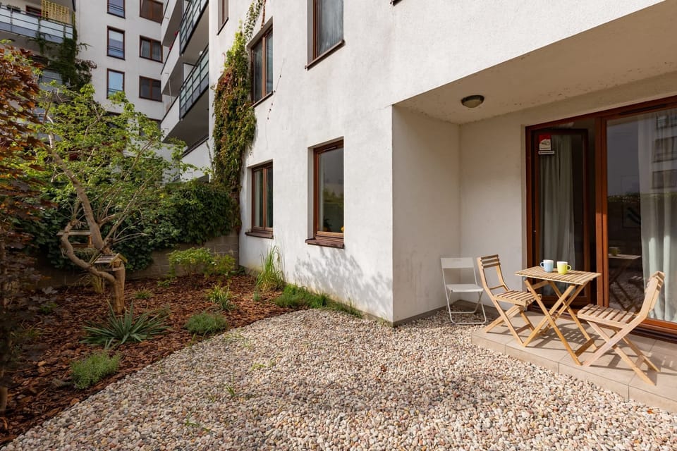 Exterior view of the building with a cozy garden space for relaxation.
