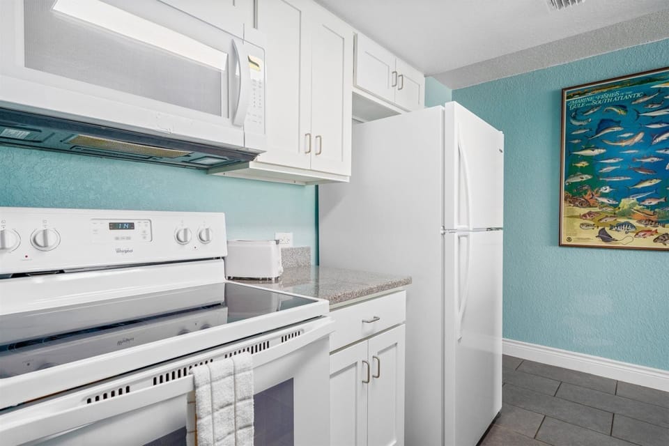 Another view of the kitchen with crisp appliances.