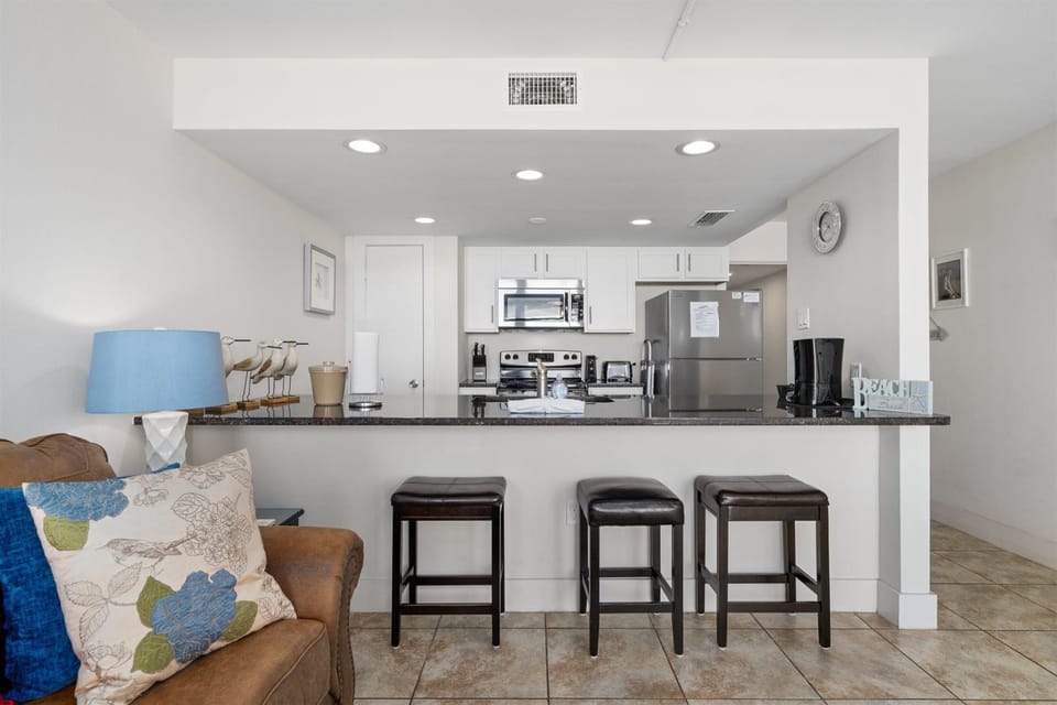 Three wooden barstools allow for comfortable seating at your bar, to enjoy drinks, a few appetizers, and great conversation after a long day out on the beach all day.