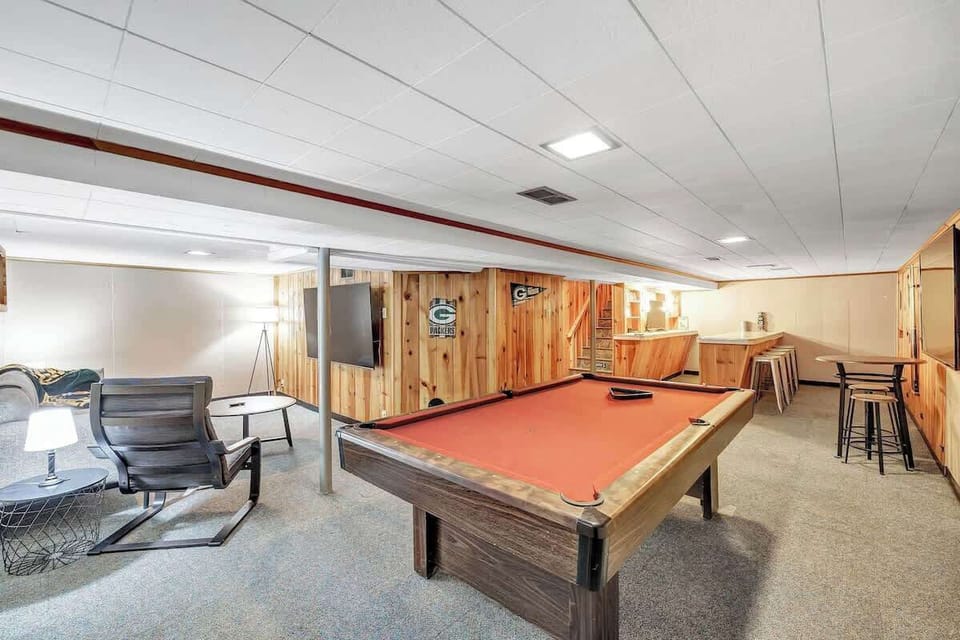 Entertainment area in the basement with a large TV and a pool table