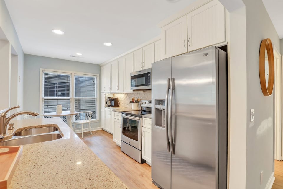 Fully equipped kitchen with stainless steel appliances, ample counter space, and a cozy breakfast nook.