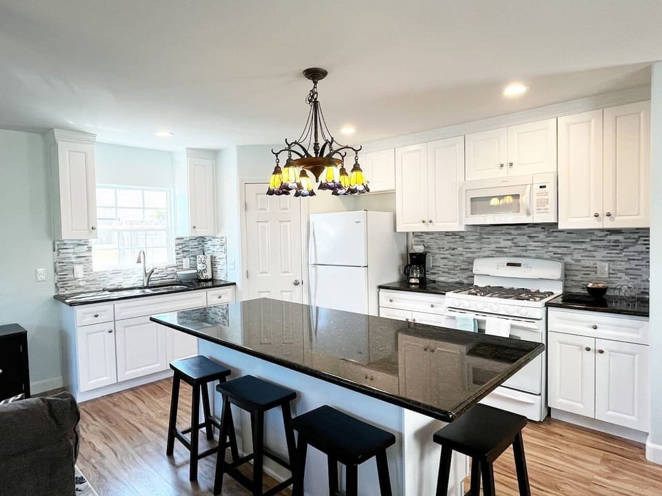 Beautiful new kitchen stocked with pots/pans, dishes, serving and cooking utensils, toaster, microwave, stovetop/oven, crock pot, hand mixer,  blender and refrigerator. Coffee, tea and sugar provided. 