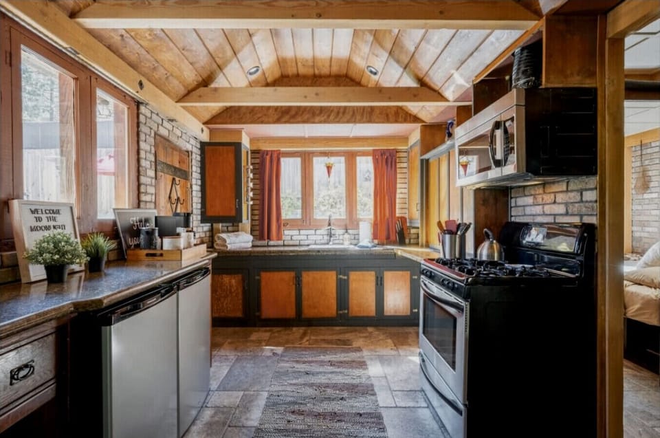 Fully equipped kitchen with two mini fridges, a full-size oven and gas stove, and a microwave for easy meal prep.