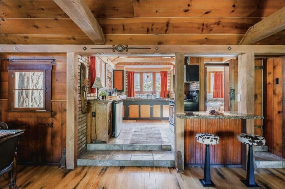 Charming rustic kitchen with warm wooden beams and cozy breakfast bar seating, perfect for enjoying home-cooked meals.