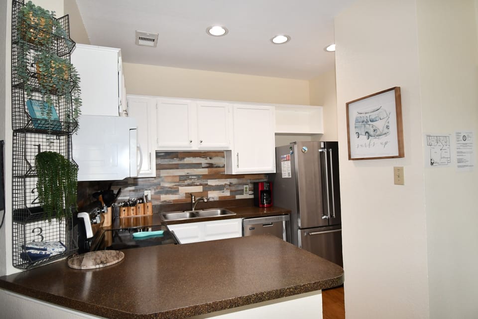 Cook your favorite meals in this fully equipped kitchen with modern appliances, granite counters, and stylish backsplash.