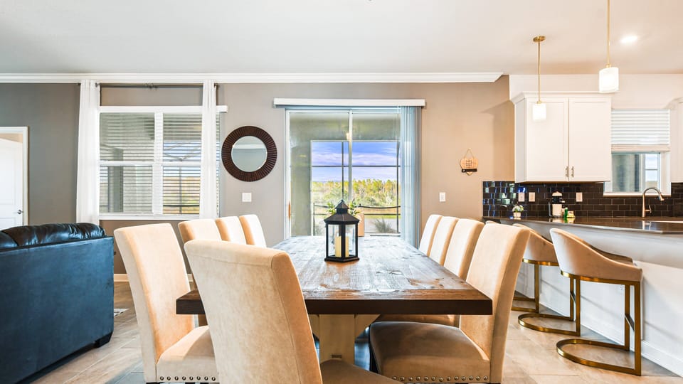 Spacious dining area with seating for 10 and scenic poolside views beyond.