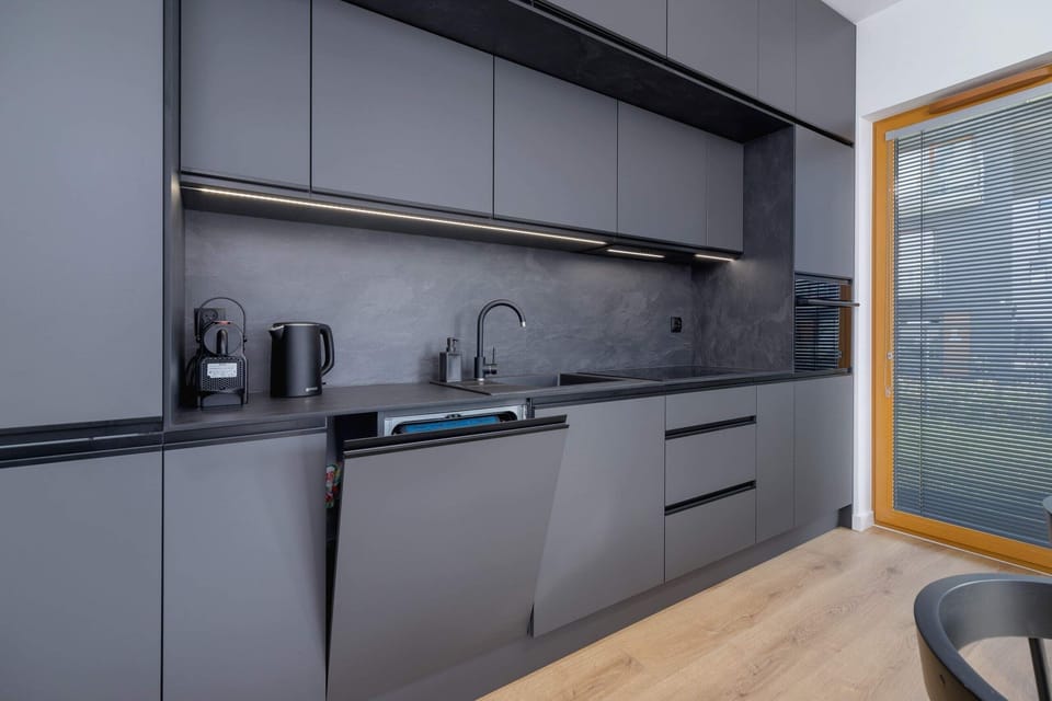 Fully equipped kitchen with dark gray cabinets and a sophisticated design.
