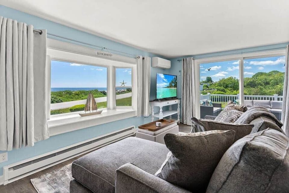 Open kitchen & living room with sleeper sofa, 50" smart TV, high-efficiency mini-split for AC/heat, and stunning views of the ocean.