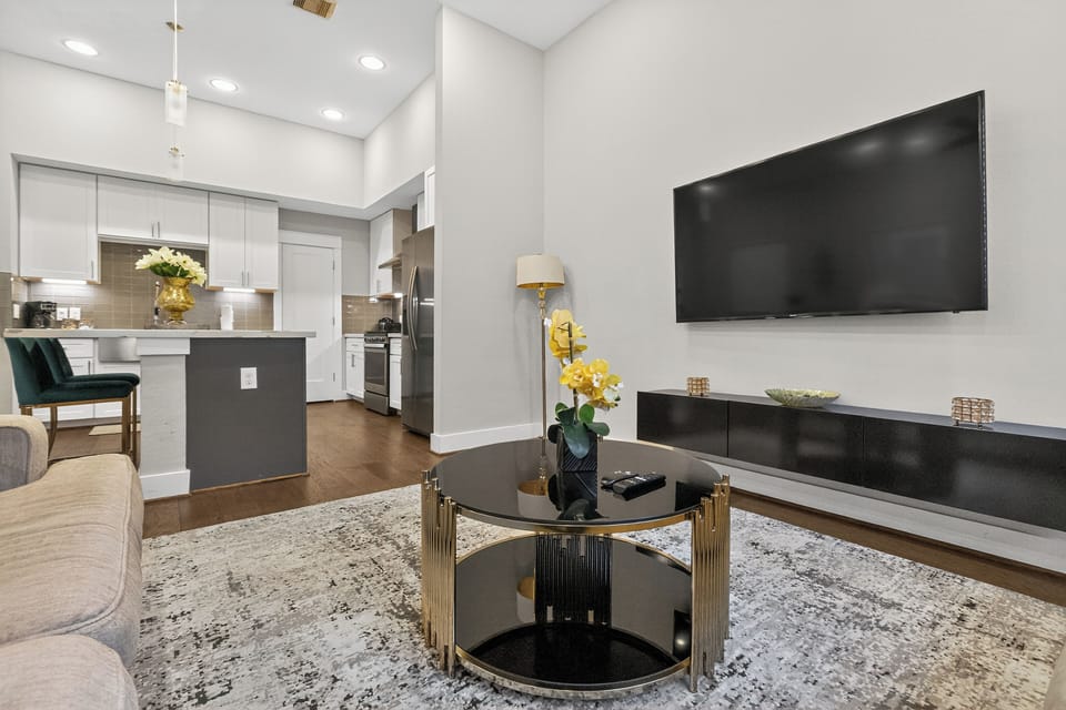 Floating shelf with 65 inches TV and a round table. 