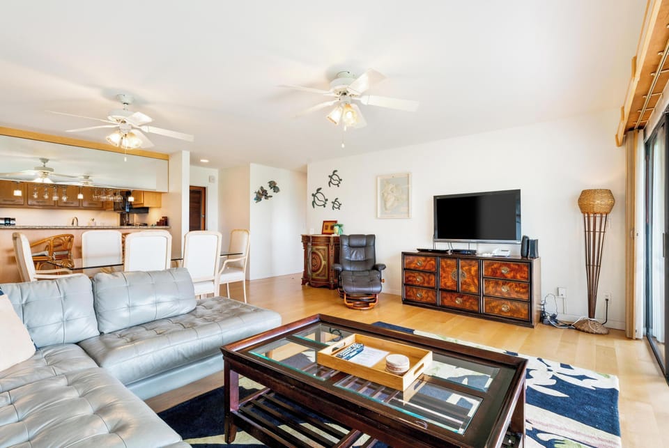 Plenty of space for you and your guests. A bright, inviting living room designed for relaxation, featuring tropical décor, comfortable seating, and direct access to the lanai.