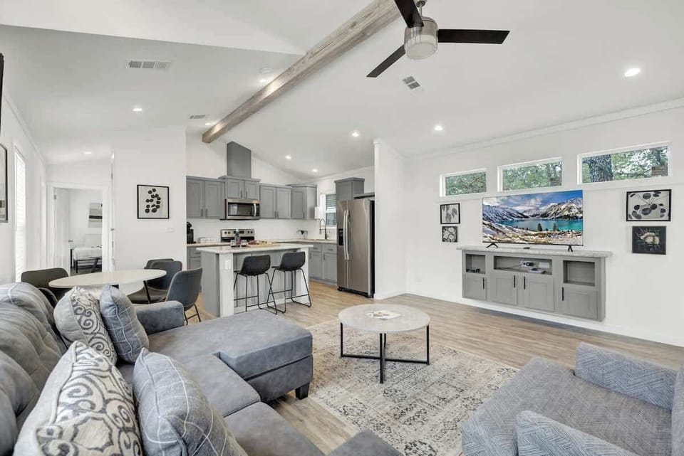 The cozy sectional sofa and large wall-mounted flat-screen television create the perfect home theater setup for relaxation and entertainment.
