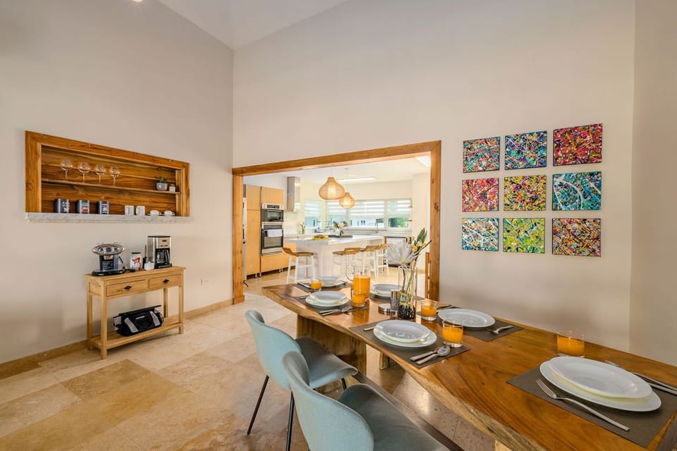 Gather around this beautiful dining table where morning coffee and shared meals become cherished memories. Bright, inviting spaces flow seamlessly into the modern kitchen beyond.