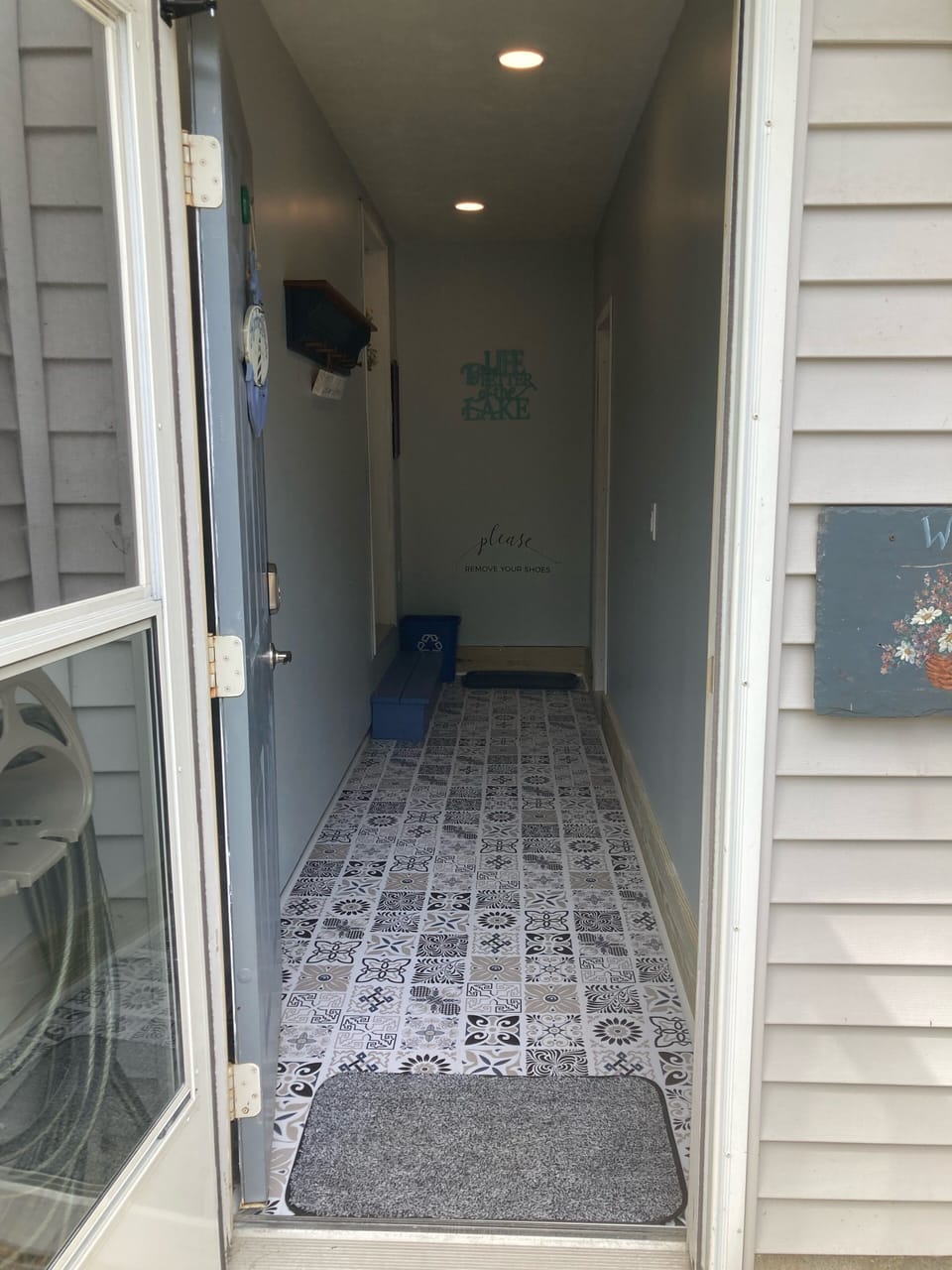 Hallway that leads to the entrance of the house. There is a handrail by the step