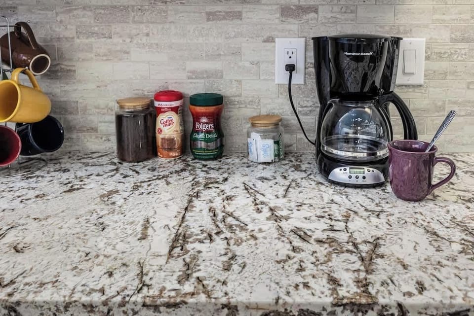 No need to worry about coffee! Our automatic drip coffee maker comes with coffee, sugar, and Coffee-mate, plus some Folgers instant decaf for your convenience. Enjoy a fresh cup anytime!