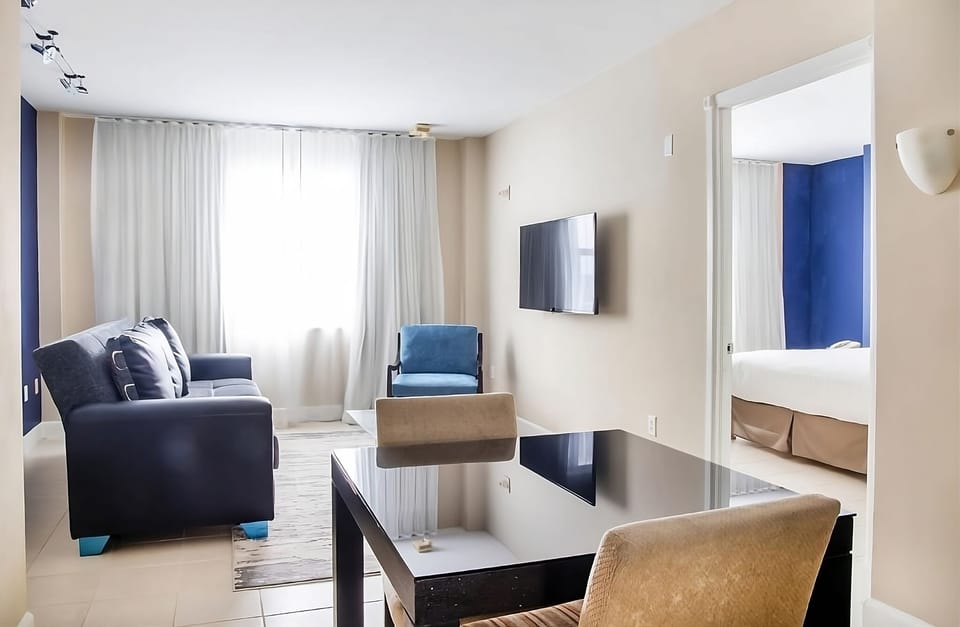 Unwind in a bright lounge with cozy seating and TV.
