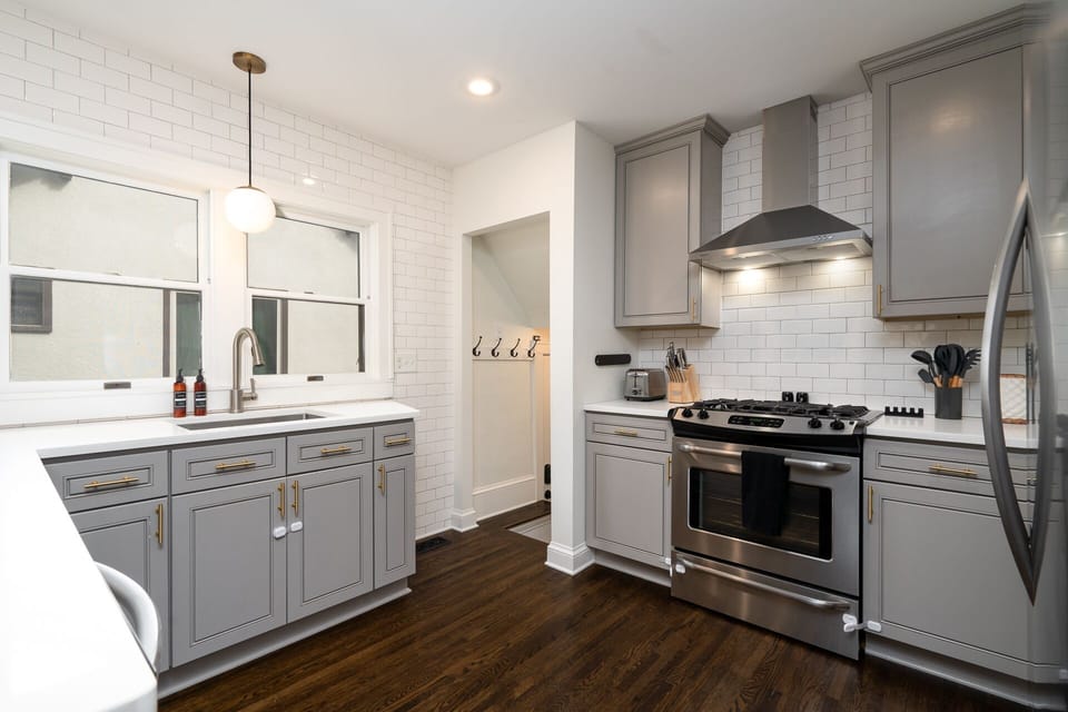 Cook your favorite meals in this stylish kitchen with modern gray cabinets, stainless steel appliances, and bright subway tile backsplash.