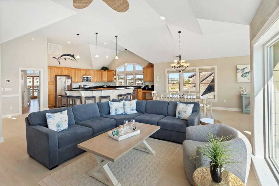 Enjoy vaulted ceilings in the spacious top-level  Living Area with a sectional couch and ocean-gazing swivel chairs.