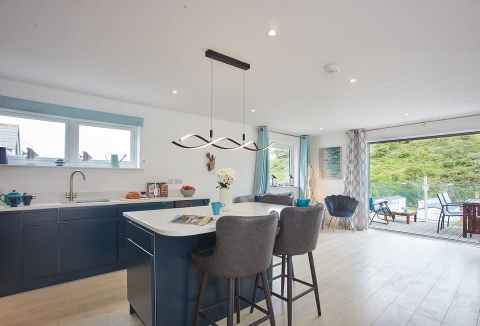 Anneth Lowen, Polzeath. Well equipped kitchen area with contemporary units, American Fridge/freezer, electric oven and ceramic hob, microwave and dishwasher