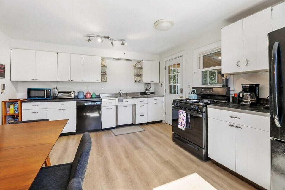 Fully equipped kitchen including drip coffee maker, coffee bean grinder, toaster oven, blender and microwave.