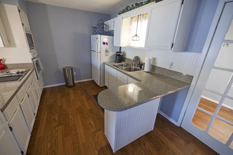 Kitchen includes stove, microwave, oven, refrigerator/freezer. Grill in backyard