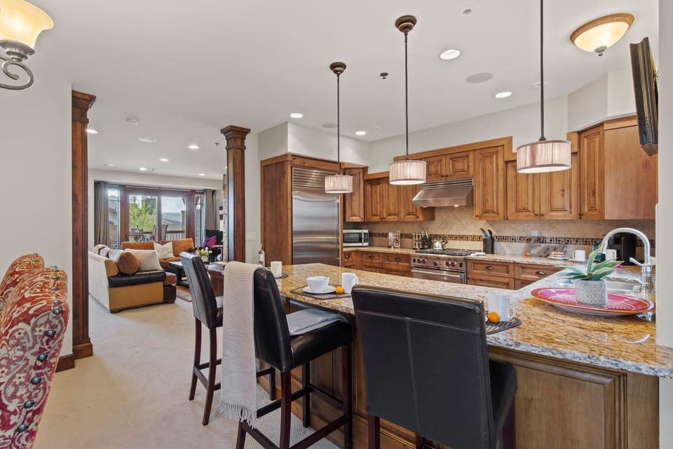 Fully Equipped Kitchen with beautiful stone countertops, stainless steel Wolf appliances, sub zero fridge, and bar seating for 3