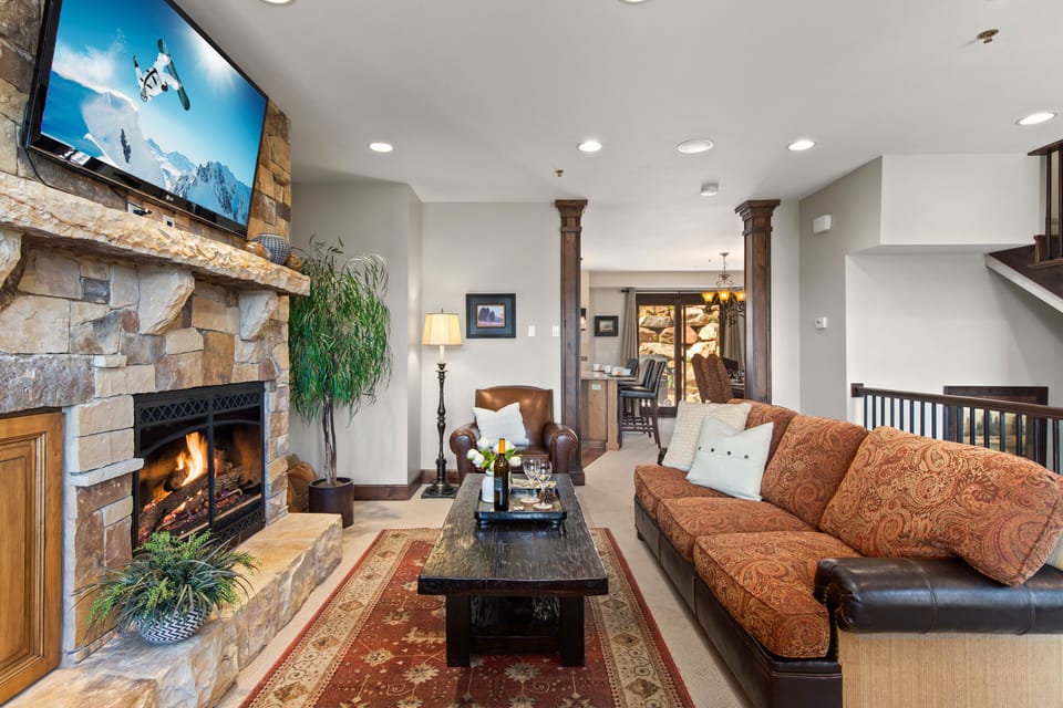 Living Room with gas fireplace, smart TV, plush furnishings including sofa sleeper, and private deck access
