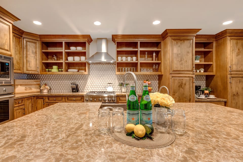 Fully Equipped Kitchen with beautiful stone countertops, hardwood floor, stainless steel Thermadore appliances, (including 3 ovens), ice maker, and island seating for three