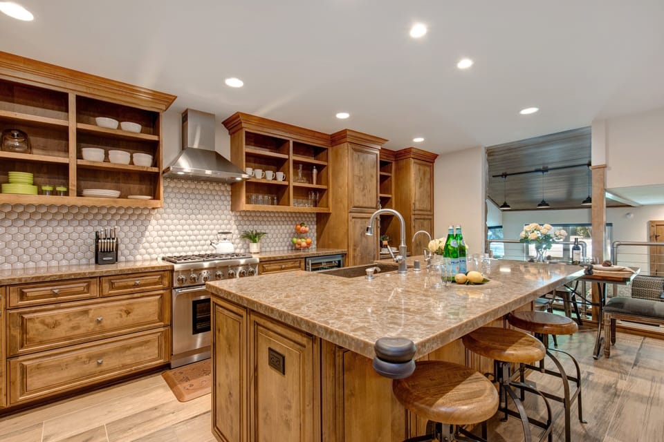 Fully Equipped Kitchen with beautiful stone countertops, hardwood floor, stainless steel Thermadore appliances, (including 3 ovens), ice maker, and island seating for three