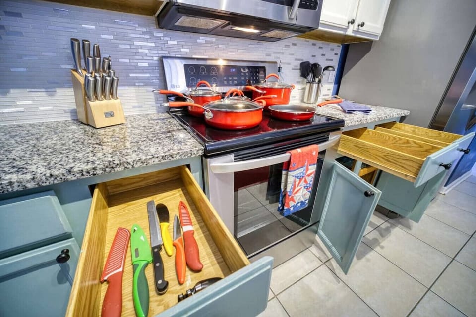 Well-equipped kitchen featuring sleek granite countertops, vibrant cookware, and organized drawers for all your cooking needs.