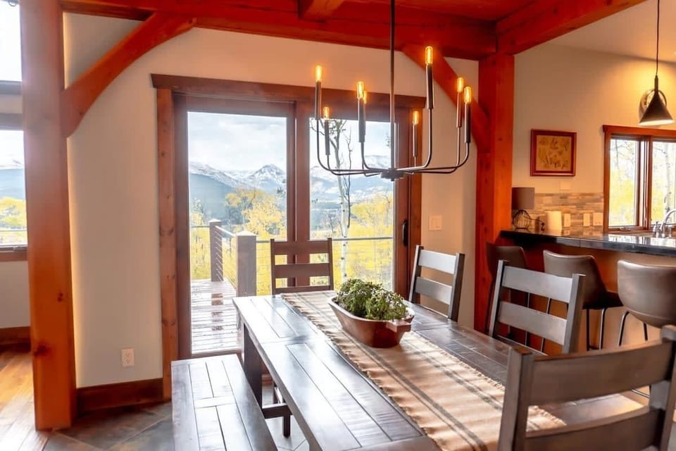 The dining space is made up of a dining table and chairs for seven with stylish overhead lighting and doors leading out to the spacious outdoor deck.